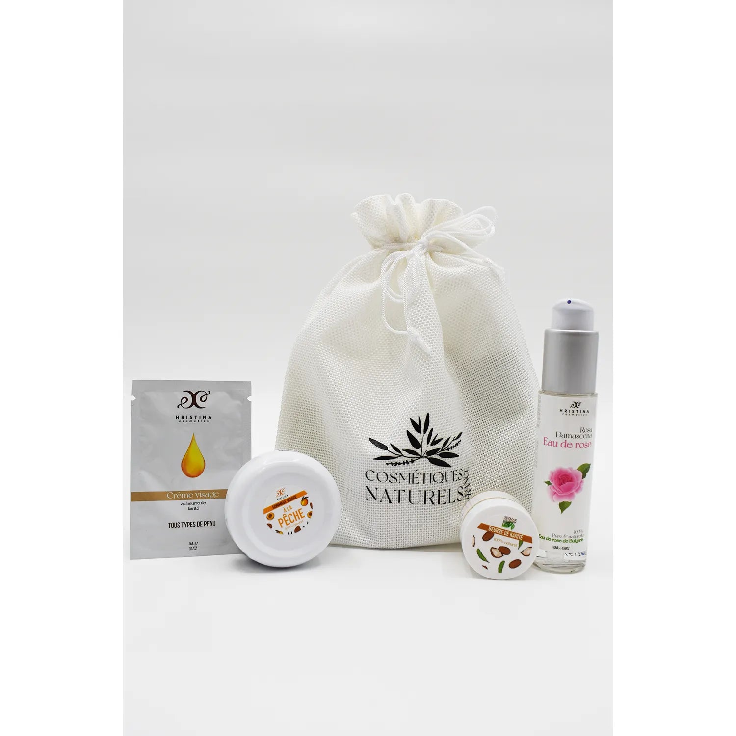Coffret visage rose de Damas et karité, flacon et pots sur fond blanc, idéal peaux sensibles, cosmétique naturel.