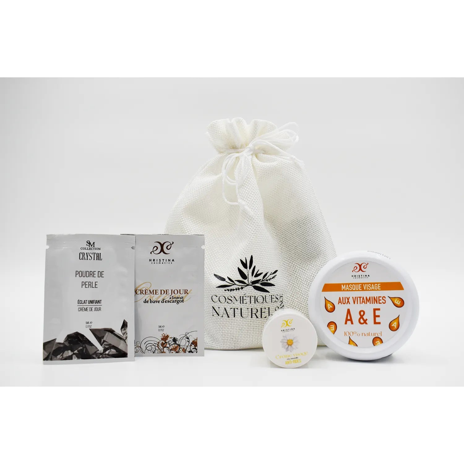 Coffret soins visage naturel anti-rides, sachets et pots, vitamines, kaolin, collagène, fond blanc.