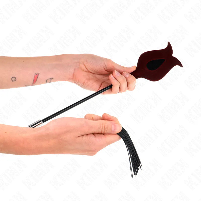 Accessoire BDSM haut de gamme, cravache en cuir noir et silicone rouge, design élégant et ergonomique, tenue en main.