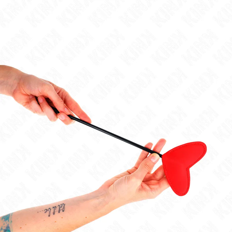 Cravache élégante en cuir rouge en forme de cœur, manche noir, pour jeux BDSM raffinés et sensations sensuelles.