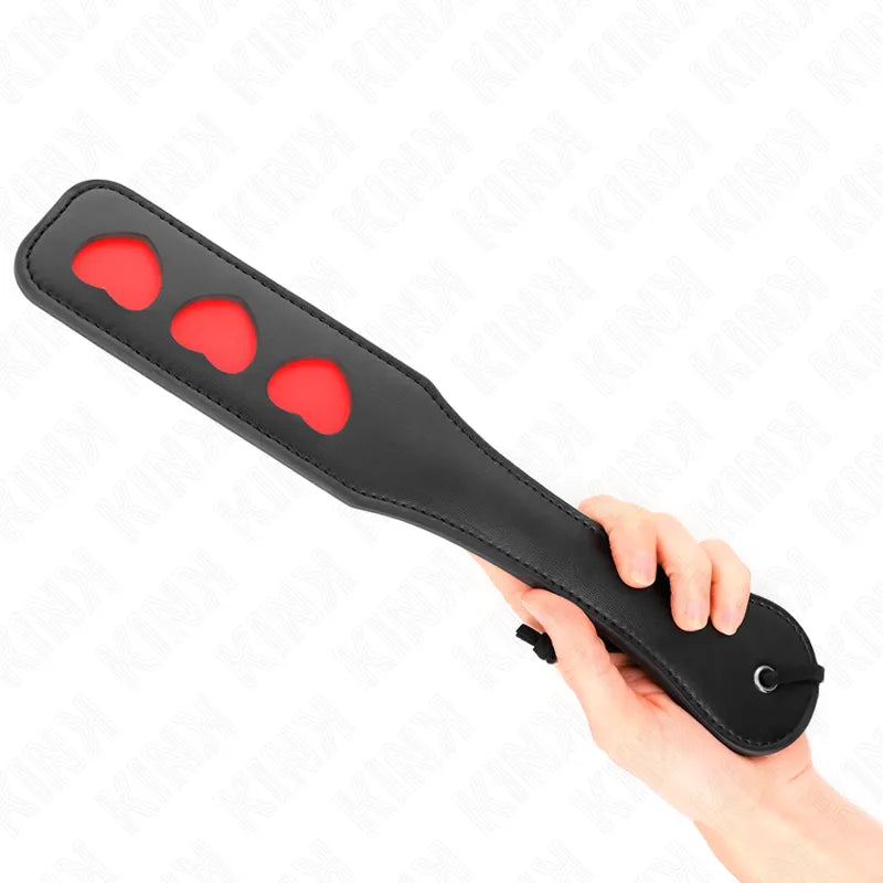 Accessoire BDSM pagaie cuir noir avec motifs rouges, design ergonomique et sophistiqué, pour séances sensuelles et élégantes.