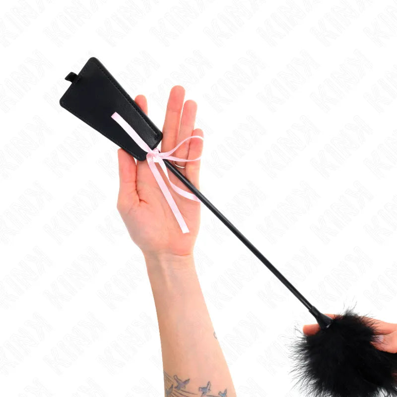 Cravache en cuir véritable noir, manche ergonomique, design élégant, ruban rose, pour expérience BDSM authentique.