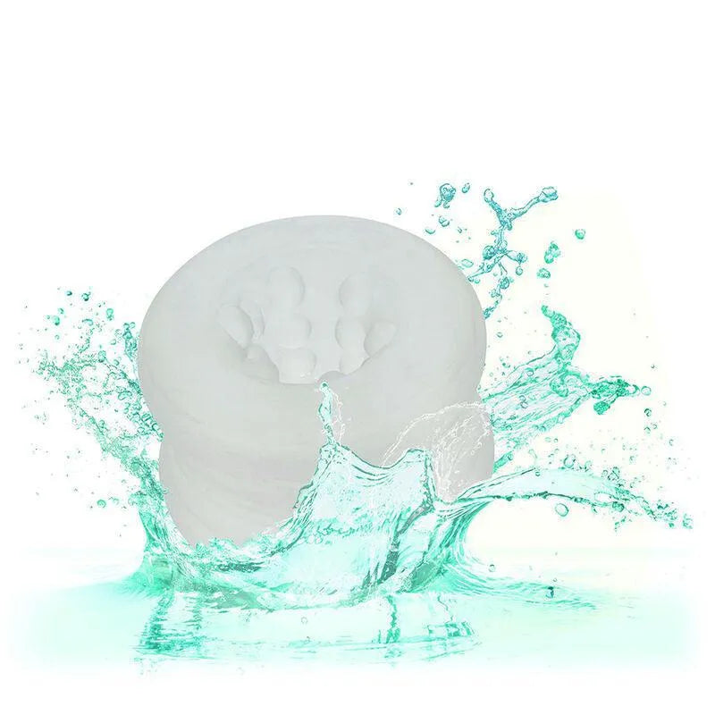 Anneau intime silicone blanc texturé, extensible, inodore, sans phtalates, sur fond éclaboussé d'eau turquoise.