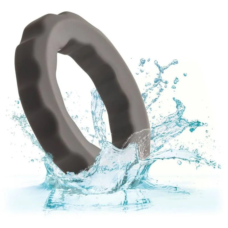 Anneau pénien silicone gris perlé, extensible, imperméable, sur fond d'eau éclaboussante, confort et endurance.