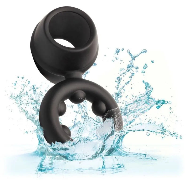 Anneau pénien noir en silicone liquide, double soutien, étanche, sur fond d'eau éclaboussée, stimulant et extensible.