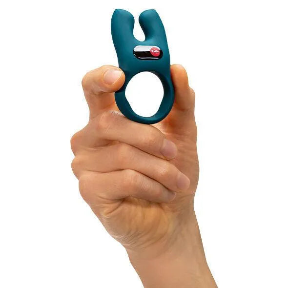 Anneau pénien vibrant bleu en silicone hypoallergénique, forme ergonomique, extensions vibrantes, tenu en main.