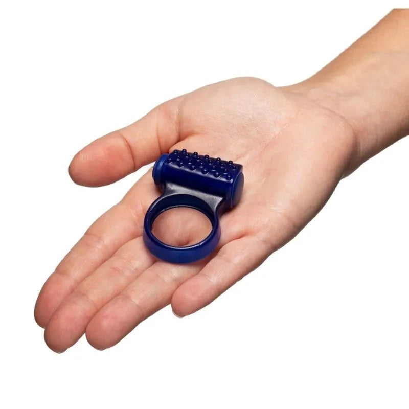 Anneau vibrant bleu en silicone doux avec pointes surélevées, ergonomique, dans une main, pour stimulation intense.