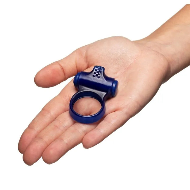 Anneau vibrant bleu silicone doux avec tête stimulante et pointes surélevées, tenu dans une main.