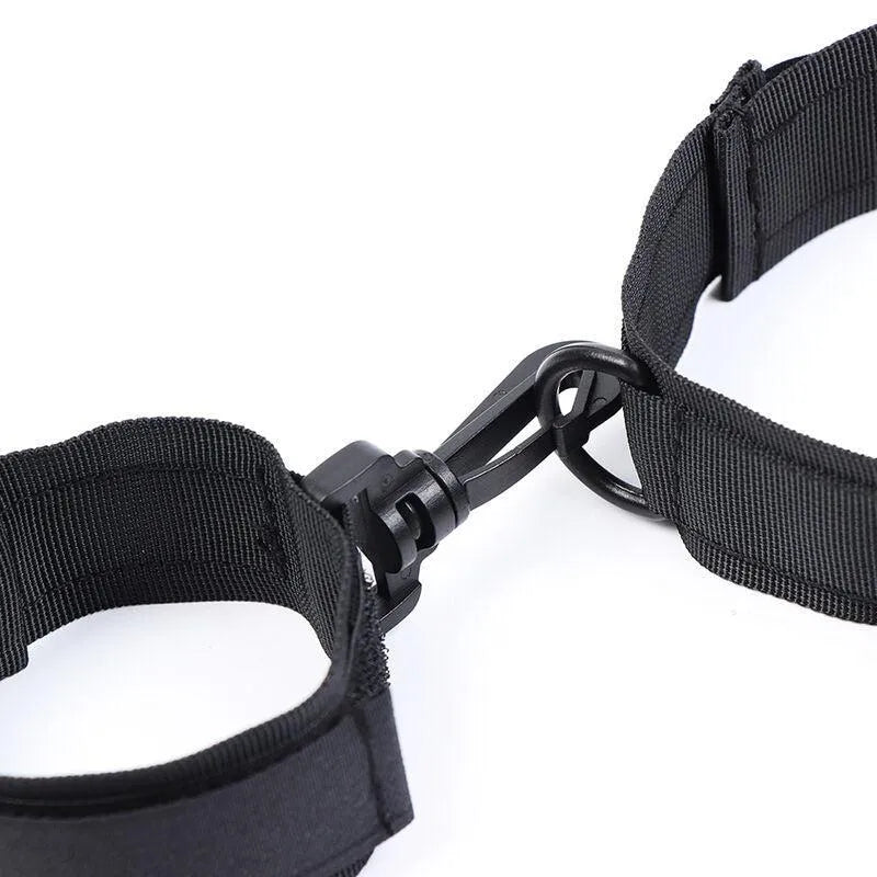 Attache BDSM noire en nylon réglable avec menottes en velcro, robuste et ergonomique pour confort et sécurité.