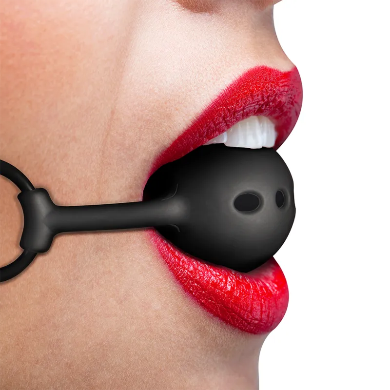 Bâillon boule silicone noir respirant, ajustable, porté par une personne, idéal pour jeux de soumission confortables.