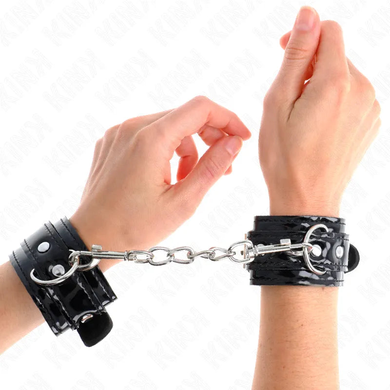 Bandes de poignet BDSM noires en cuir vegan avec boucles robustes et chaîne métallique, élégantes et éthiques.