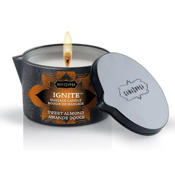 Bougie de massage amande douce allumée, pot noir élégant, couvercle à côté, ambiance intime et apaisante.