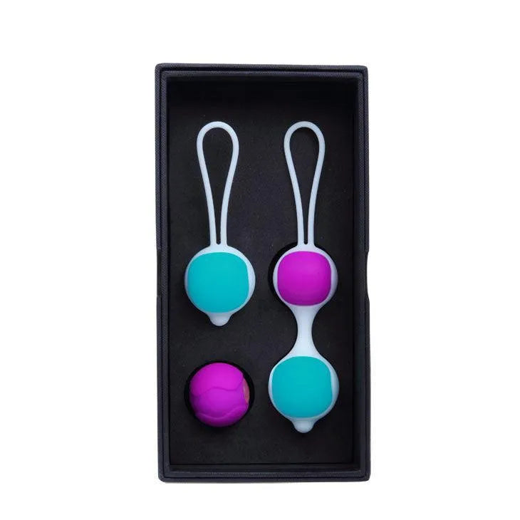 Boules de geisha en silicone bleu et rose, interchangeables, avec cordons blancs, dans un coffret noir.