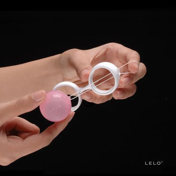 Boules Kegel roses en silicone médical avec poids interchangeables, tenues par une main, pour renforcement pelvien post-pa...