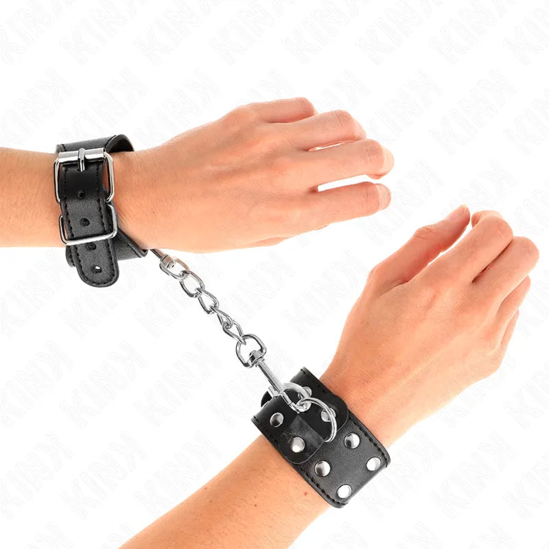 Bracelets BDSM en cuir noir avec boucles et anneaux métalliques, ajustables et rembourrés, pour confort et sécurité.