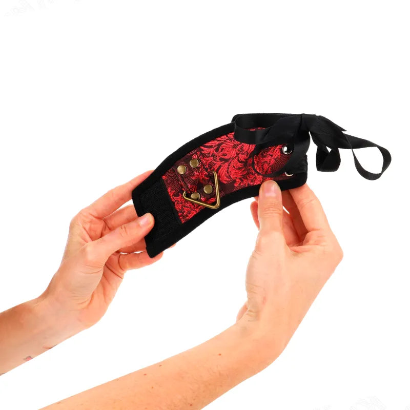 Bracelet BDSM cuir noir et rouge, élégant et robuste, avec boucles résistantes, pour sessions confortables et sécurisées.