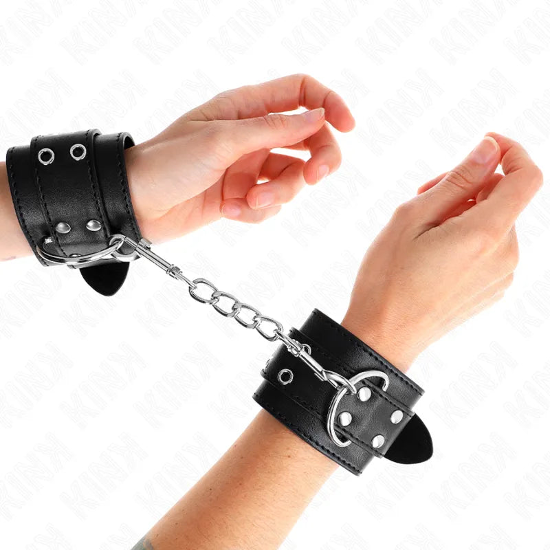 Bracelets BDSM cuir noir, boucles métalliques robustes, chaîne centrale, design élégant et durable pour confort et sécurité.