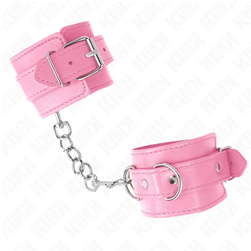 Bracelets BDSM en cuir rose, rembourrés, avec boucles robustes et anneaux métalliques, pour confort et sécurité.
