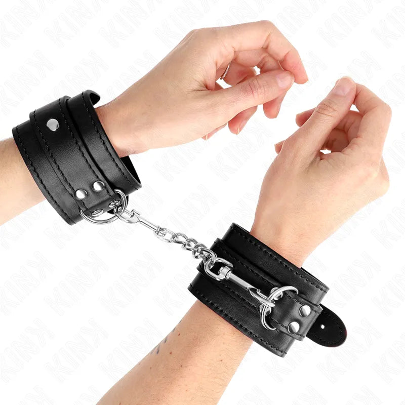 Bracelets BDSM en cuir noir, rembourrés, cloutés, avec chaîne métallique, ajustables pour confort et style élégant.