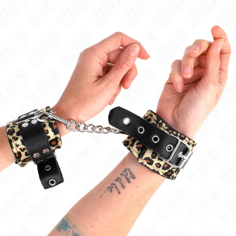 Bracelets BDSM cuir noir et imprimé léopard, ajustables, avec boucles métalliques et chaîne, pour confort et sécurité.