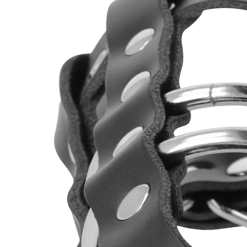 Cage de chasteté en cuir végétalien noir avec anneaux métalliques, ajustable et ventilée pour confort et sécurité.