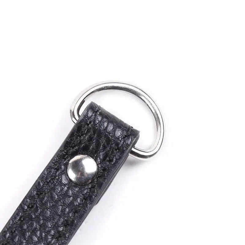 Anneau pénien ajustable en simili cuir noir avec chaîne métal robuste, finition élégante pour confort et style intimes.