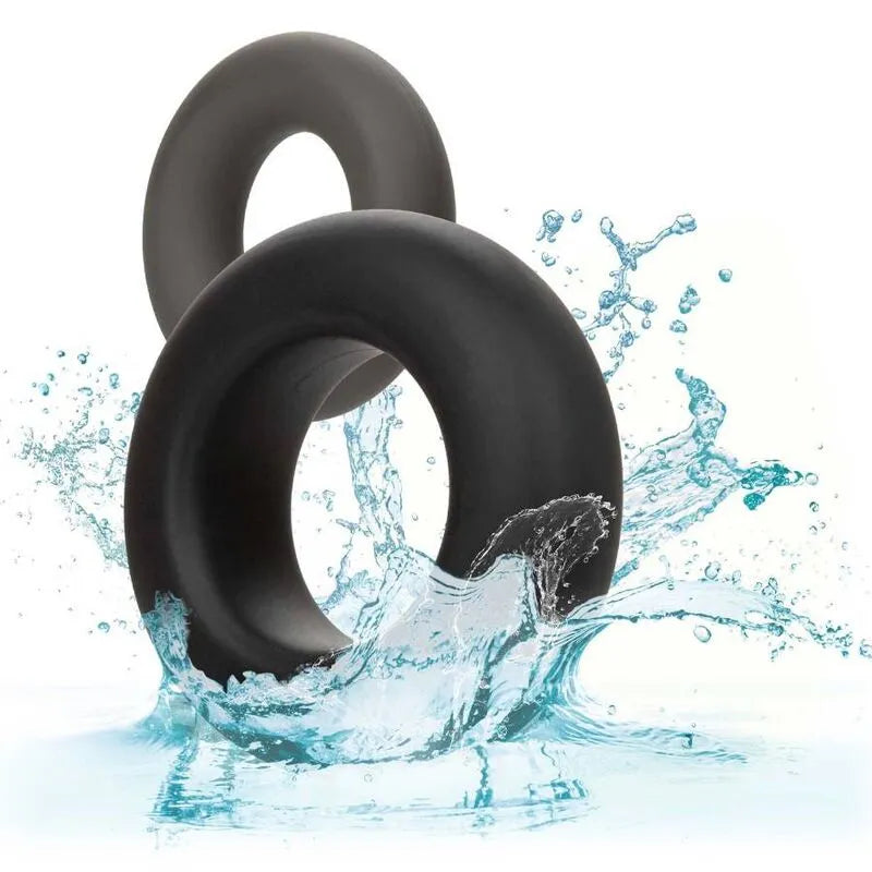 Anneaux péniens silicone noir, deux tailles, étanches, sans couture, sur fond éclaboussures d'eau, confort et durabilité.
