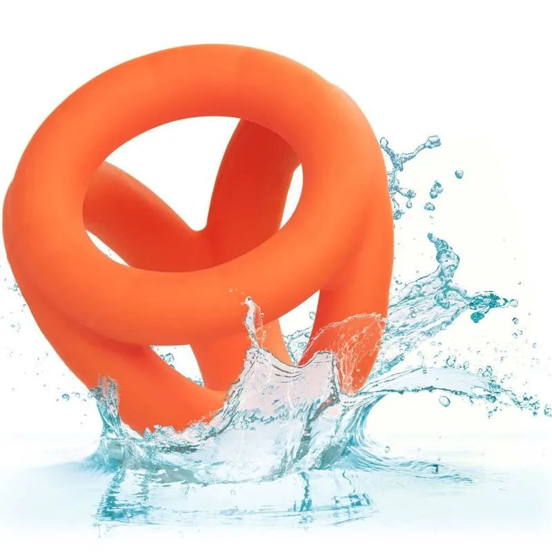 Anneau pénien triple en silicone orange, ergonomique et durable, éclaboussé d'eau pour illustrer son imperméabilité.