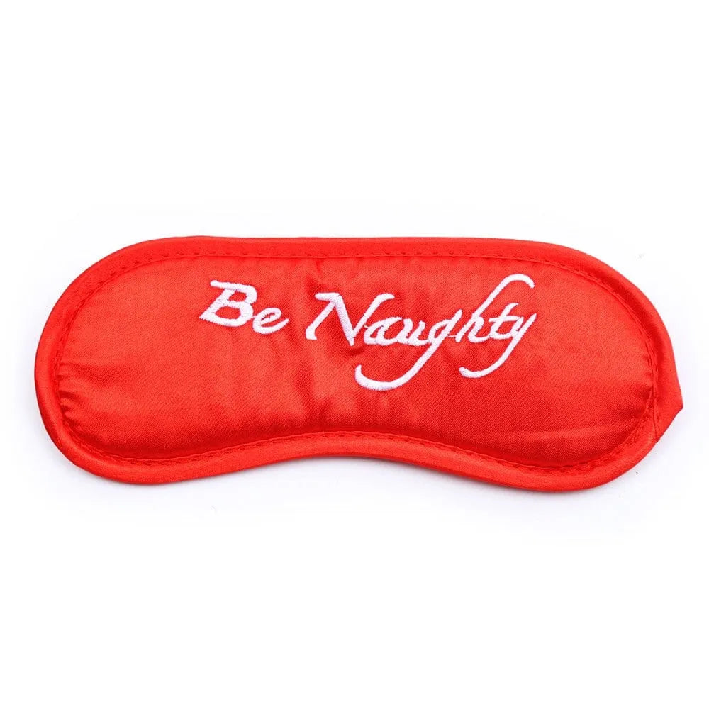 Masque rouge en tissu avec élastique, inscription Be Naughty, accessoire du coffret coquin pour soirée sensuelle.