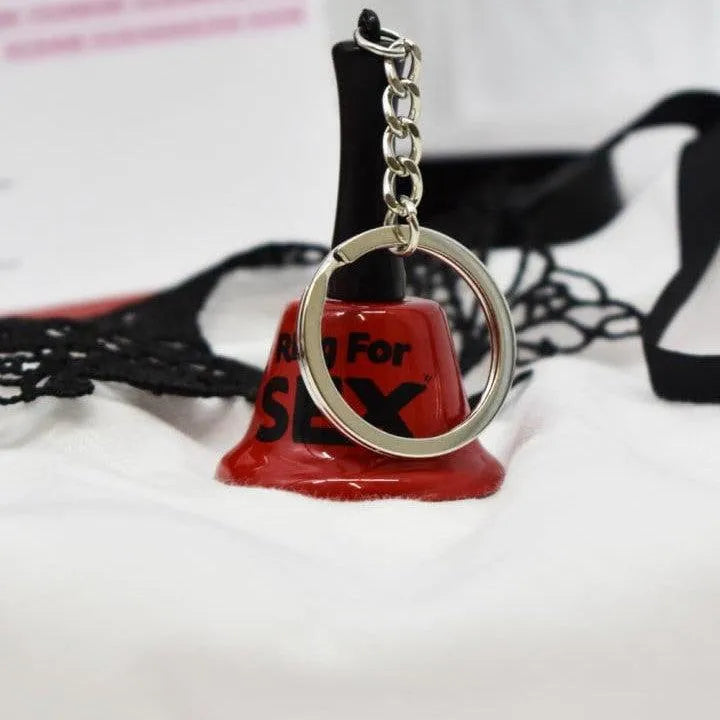 Cloche rouge avec chaîne sur fond blanc, élément du Coffret Coquin Édition Limitée pour moments intimes et sensuels.