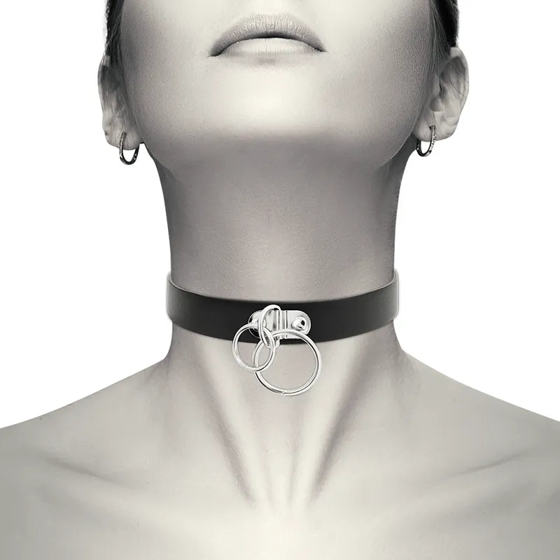 Collier BDSM noir en similicuir végétalien, ajustable, avec anneaux métalliques, porté autour du cou.