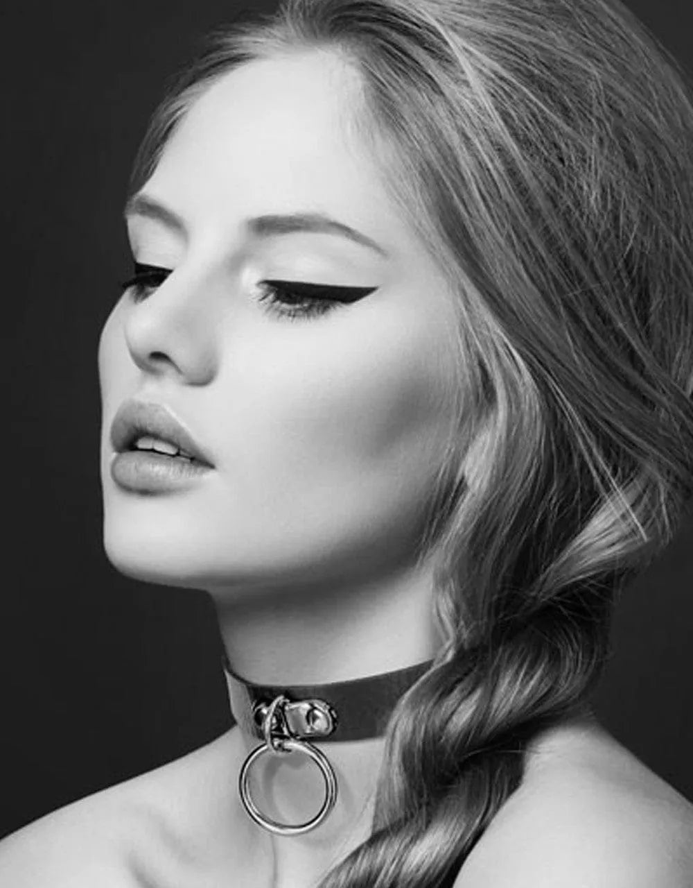 Collier bondage cuir noir avec anneau argenté, réglable façon ceinture, idéal pour jeux érotiques et fétichistes.