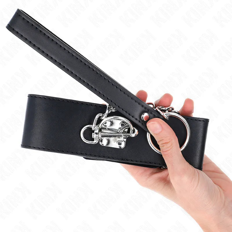Collier et laisse BDSM en cuir noir, design élégant avec boucles métalliques, tenue en main.