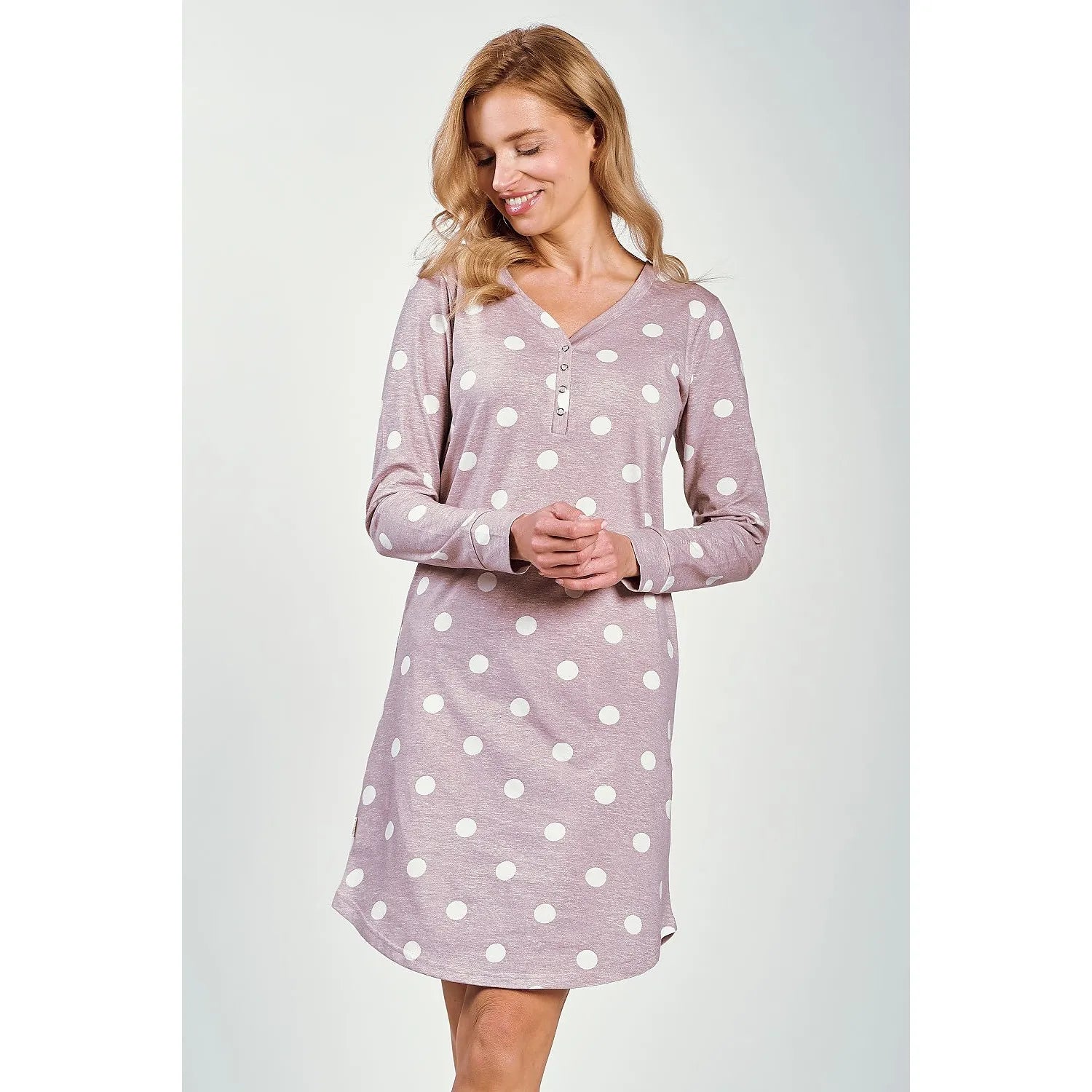 Chemise de nuit rose pâle à pois blancs, manches longues, encolure V avec boutons, coupe ample mi-cuisse.