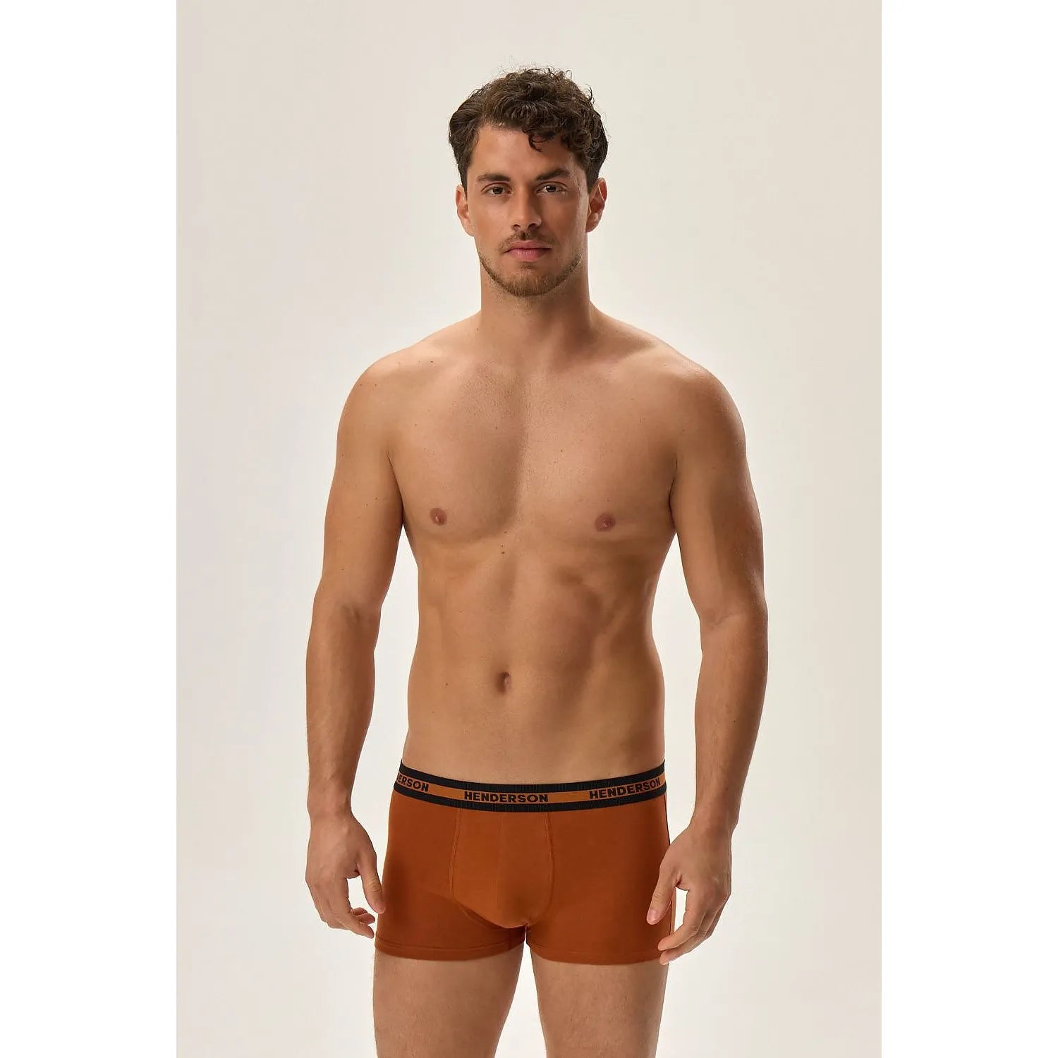 Boxers hommes ajustés orange, ceinture noire logo Henderson, confort coton extensible, modèle sur fond neutre.