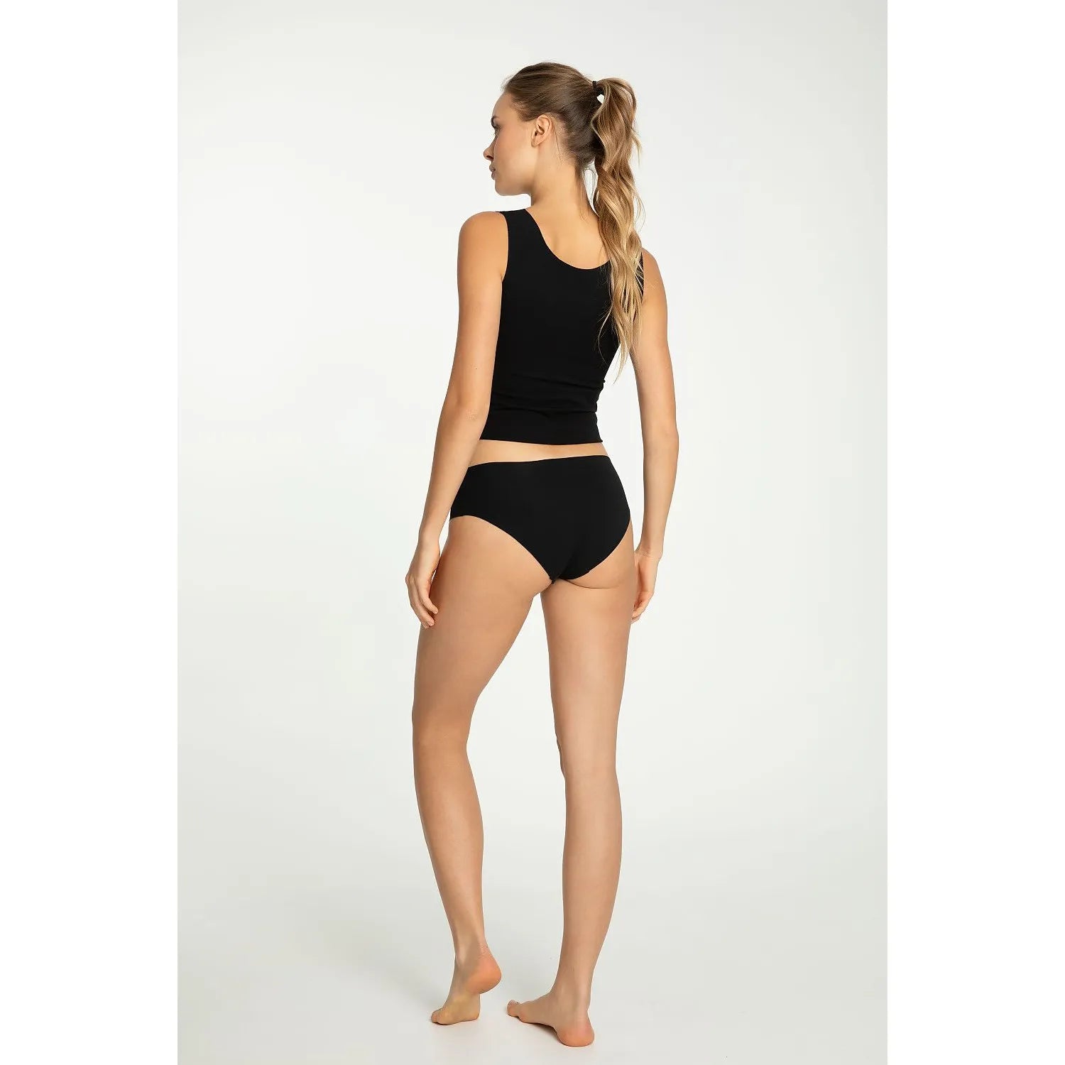 Femme portant ensemble lingerie noire Julimex Model 220541, sans coutures, ajustement parfait, vue de dos.