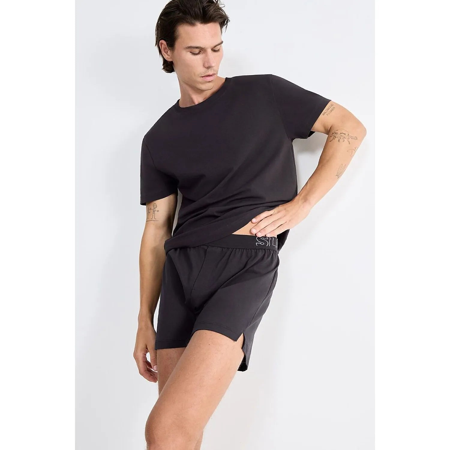 Boxer homme noir Sloggi en coton bio, coupe classique, élastique à la taille, porté par un modèle, confort moderne.