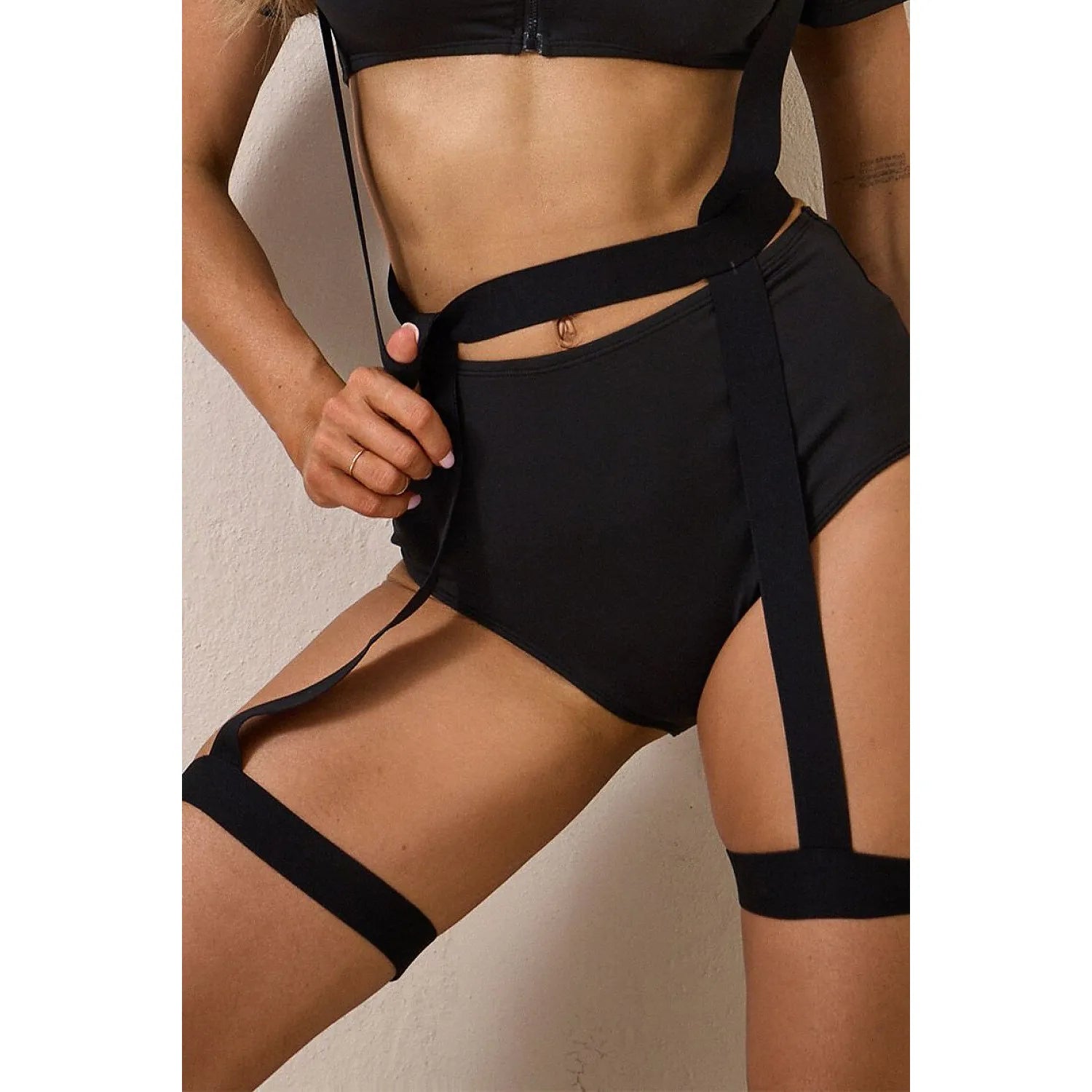 Costume policière sexy noir avec haut zippé, bas taille haute, écusson et casquette, style uniforme audacieux.
