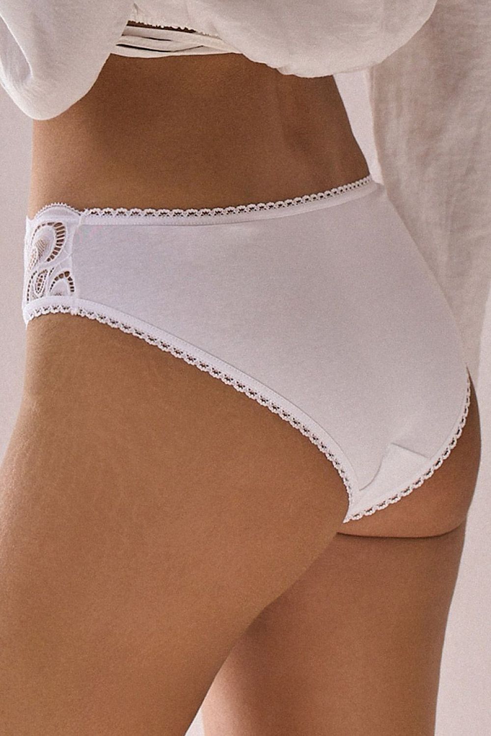 Culotte blanche en coton avec dentelle décorative sur le côté, coupe classique et arrière lisse pour confort quotidien.