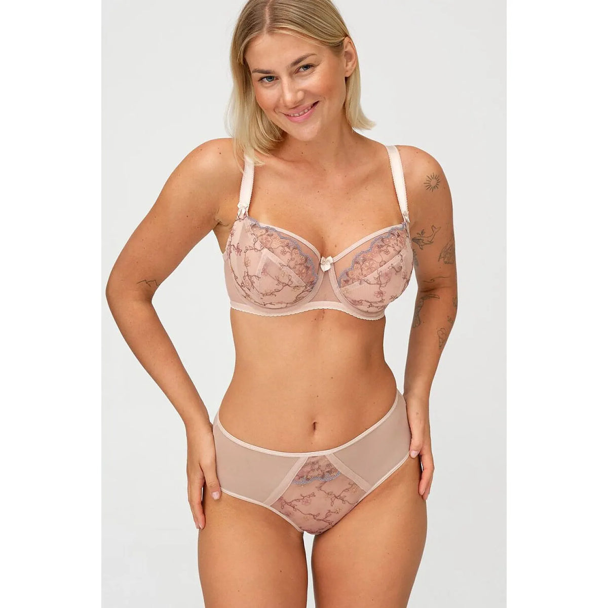 String Dalia beige avec broderie florale, côtés transparents, arrière lisse, coupe taille moyenne pour confort et élégance.