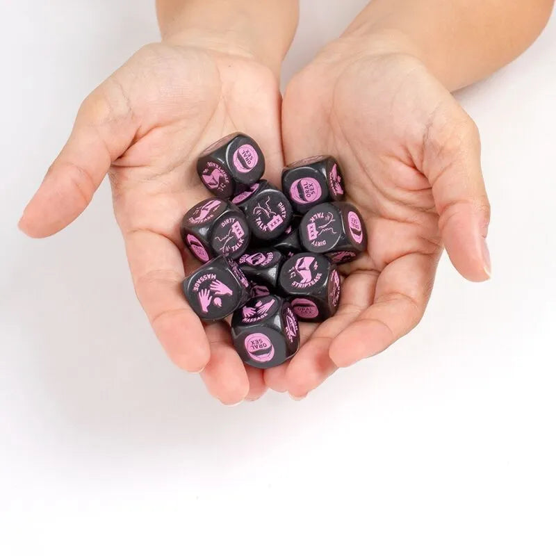 Dés érotiques noirs 20mm avec symboles roses, tenus dans des mains, pour moments intimes et jeux de couple.