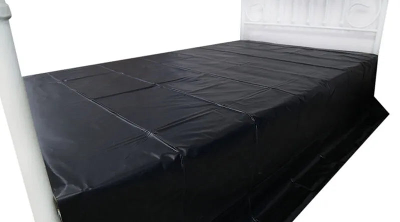 Drap jetable noir en PVC sur lit, imperméable et résistant, idéal pour jeux adultes et protection hygiénique.