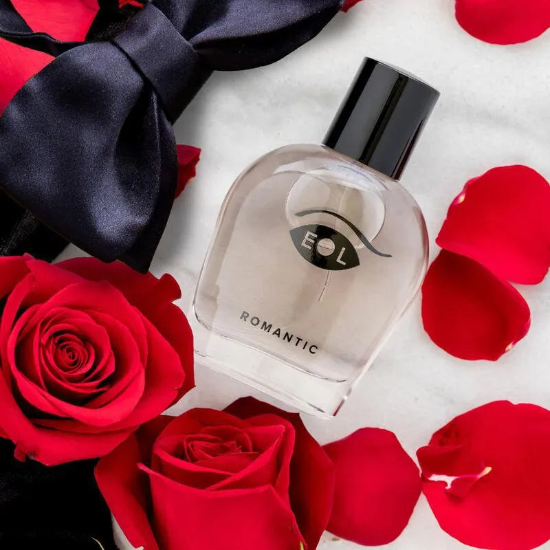 Flacon transparent de cologne masculine romantique, entouré de pétales rouges, avec bouchon noir élégant.