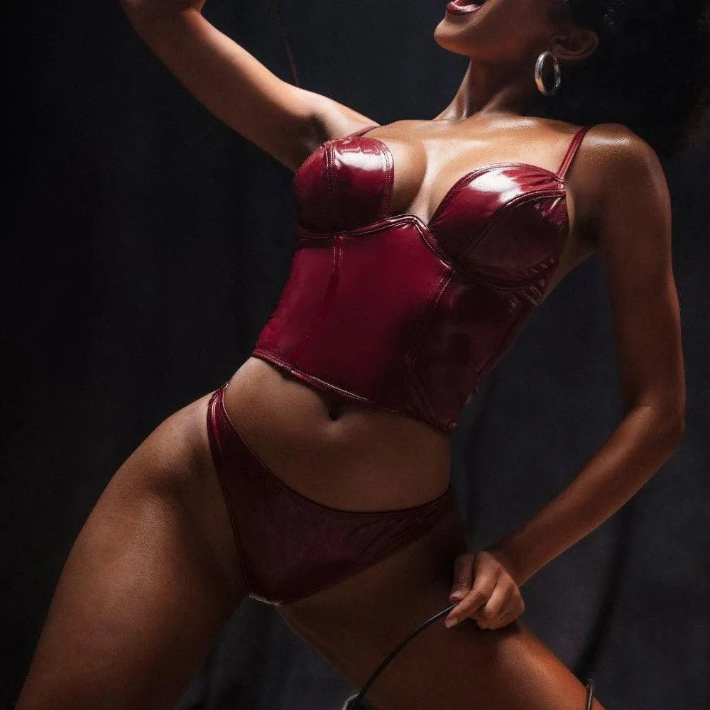 Ensemble vinyle rouge deux pièces, bustier armature, bretelles réglables, string assorti, fermeture éclair arrière.