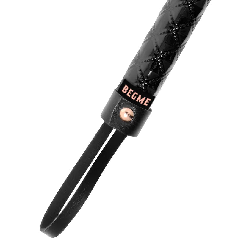 Fouet BDSM noir en cuir végétalien avec poignée ergonomique, sangles souples, détails en métal, marque BEGME visible.