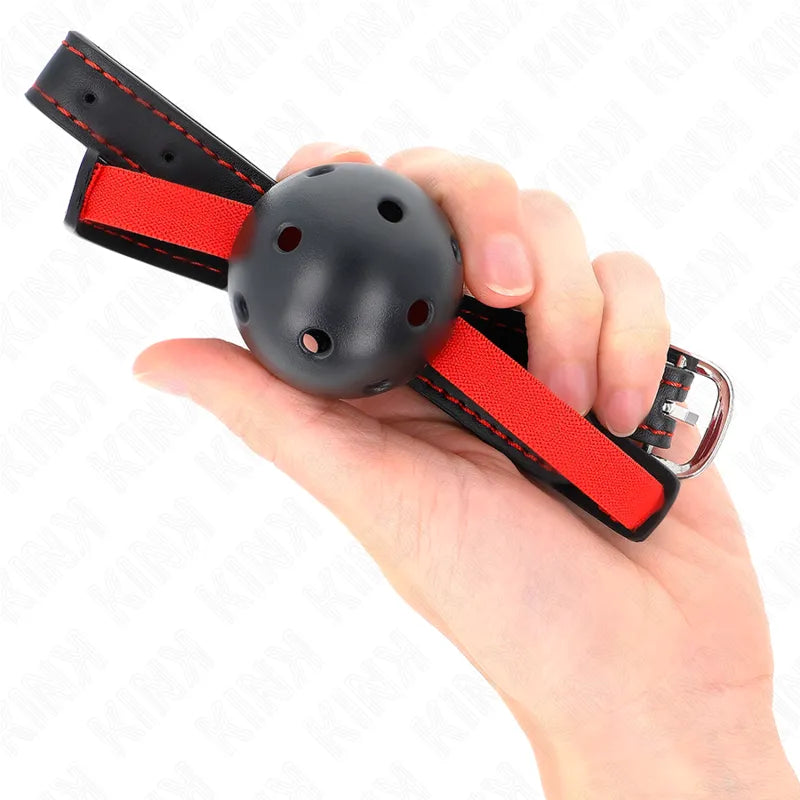 Gag BDSM en silicone noir avec bretelles rouges ajustables, design ergonomique et sécurisé, tenu en main.