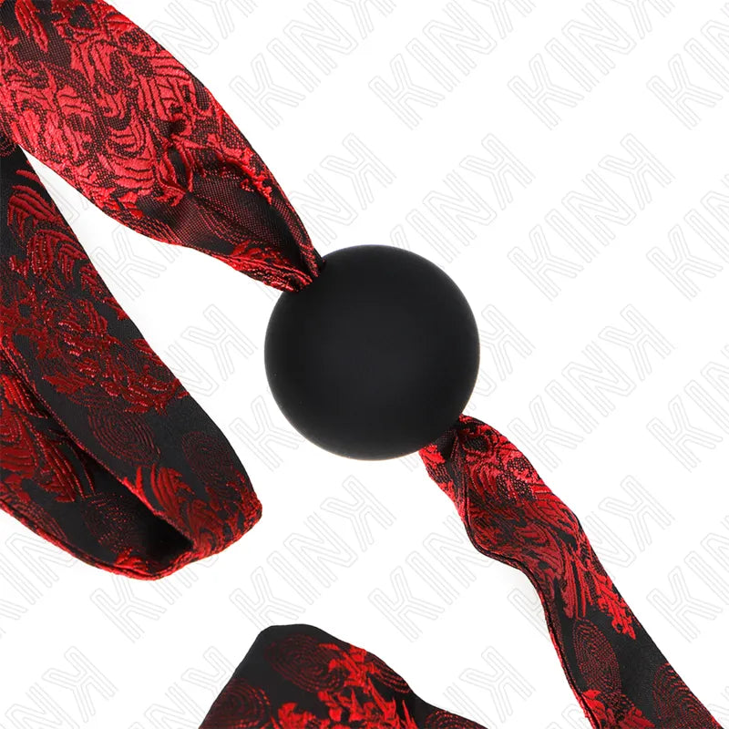 Gag BDSM en silicone noir avec sangle ajustable rouge à motifs, élégant et confortable pour expériences sécurisées.