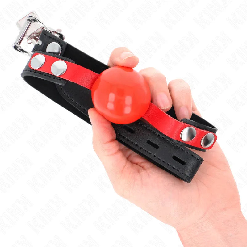 Gag BDSM en silicone rouge, ergonomique et réglable, avec sangle noire et rivets métalliques pour confort et sécurité.