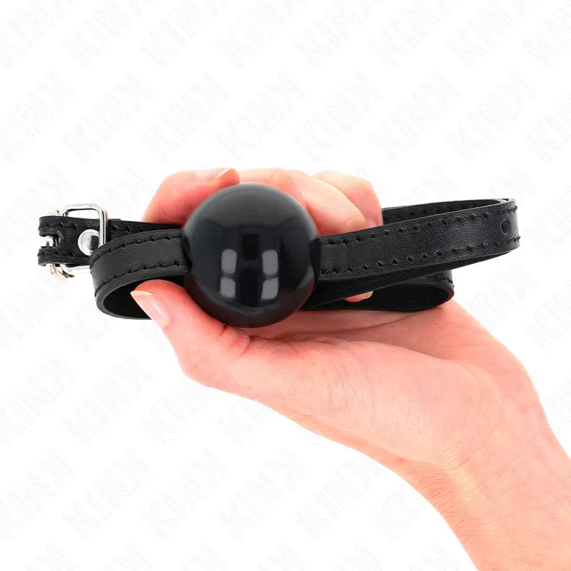Gag BDSM en silicone noir avec harnais ajustable en cuir, ergonomique et sécurisé, tenu dans une main.