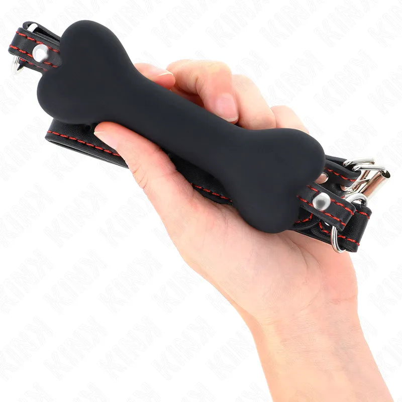 Gag BDSM en silicone noir ergonomique en forme d'os, avec sangles ajustables en cuir noir et coutures rouges.